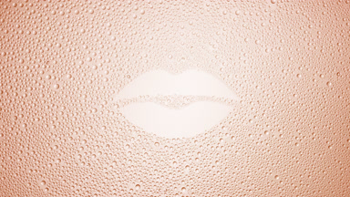 Lip shape print blown off the wet glass on beige background