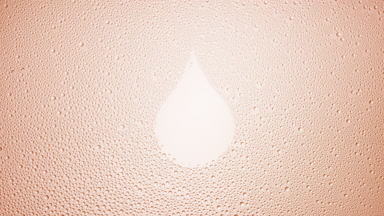 Drop shape print blown off the wet glass on beige background