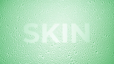 Skin word blown off the wet glass on green background