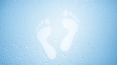 Footprints blown off the wet glass on blue background
