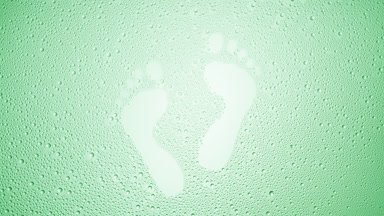 Footprints blown off the wet glass on green background