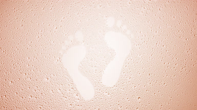 Footprints blown off the wet glass on beige background