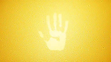 Handprint blown off the wet glass on yellow background