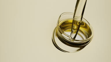 Yellow oil is being poured into yellow oil on white background