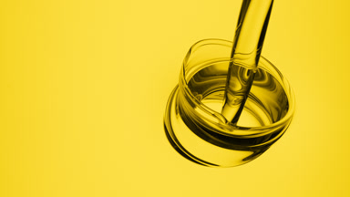 Yellow oil is being poured into yellow oil on yellow background