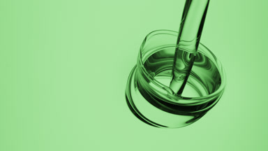Green oil is being poured into green oil on green background