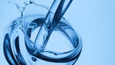 Blue tansy oil is being poured into blue oil on blue background
