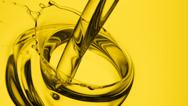 Chamomile oil is being poured into oil on yellow background