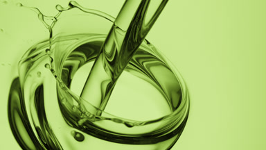 Hemp oil is being poured into green oil on green background