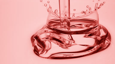 Side view macro shot of pink oil is being poured into pink oil