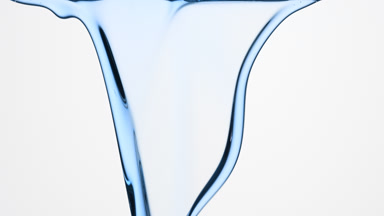Blue oil is flowing and dripping down on grey background
