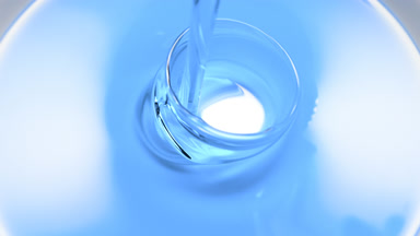 Macro shot of cyan oil is being poured into white ceramic dish