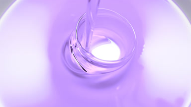 Macro shot of violet oil is being poured into white ceramic dish