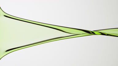 Macro of green liquid is flowing and dripping on grey background