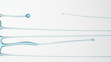 Macro of cyan fluid is flowing and dripping on grey background
