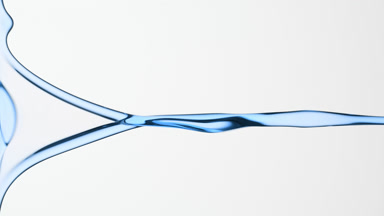 Macro of blue fluid is flowing and dripping on grey background
