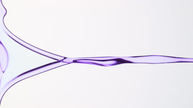 Macro of purple fluid flowing and dripping on grey background