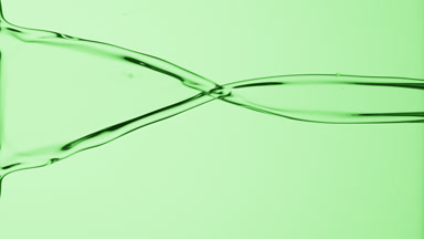 Macro of green liquid is flowing and dripping on green background