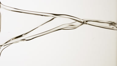 Transparent fluid is flowing and dripping on grey background
