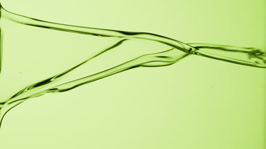 Macro of green fluid is flowing and dripping on green background