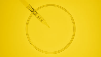 Dropper takes yellow fluid from watch glass and drips it back