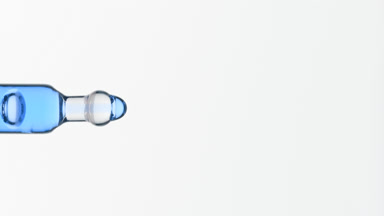 Cyan fluid is dripping from lab dropper on grey background