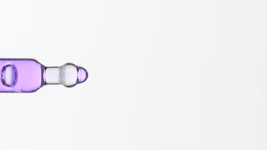 Violet fluid is dripping from lab dropper on grey background