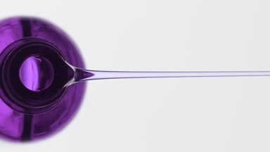 Violet reagent bottle being tilted and violet oil pours from it