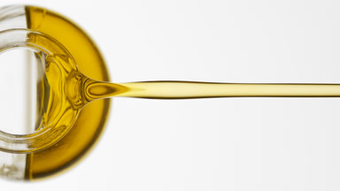 Reagent bottle is being tilted and olive oil pours from it