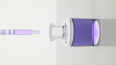 Lab dropper drips violet liquid into bottle on grey background