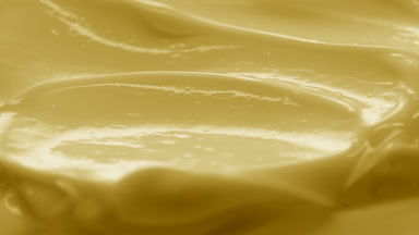 Side view macro turntable yellow cosmetic cream texture shot