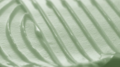 Macro turntable crane shot of green cosmetic cream texture