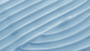 Side view macro turntable shot of blue cosmetic cream surface