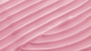 Side view macro turntable shot of pink cosmetic cream surface