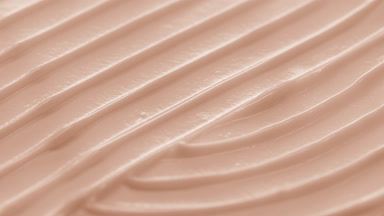 Side view macro turntable shot of beige cosmetic cream surface