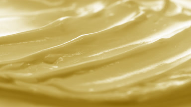 Macro crane shot of yellow cosmetic cream surface