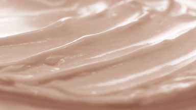 Macro crane shot of beige cosmetic cream surface