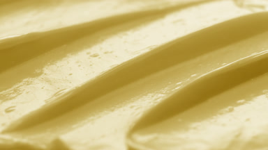 Macro crane yellow cosmetic cream surface shot