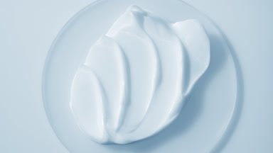 Extreme close-up jib shot of blue cream on watch glass round