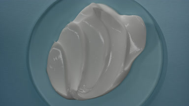 Shot of white cream on watch glass round with changing lighting