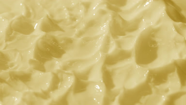 Top view macro shot of yellow cream with changing lighting
