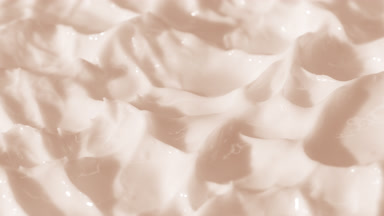 Side view macro turntable shot of beige cosmetic cream texture