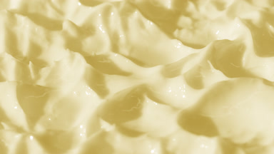 Side view macro turntable shot of yellow cosmetic cream texture
