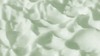 Side view macro turntable shot of green cosmetic cream texture