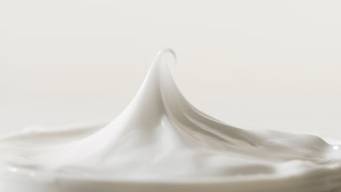 Macro shot of white cap has been removed from the white cream