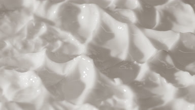 Side view macro turntable shot of white day cream surface