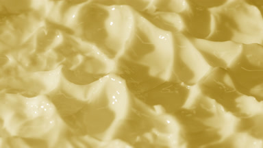 Side view macro turntable shot of yellow day cream surface
