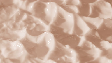 Side view macro turntable shot of beige day cream surface