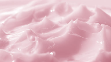 Macro crane turntable shot of pink skin care cream surface