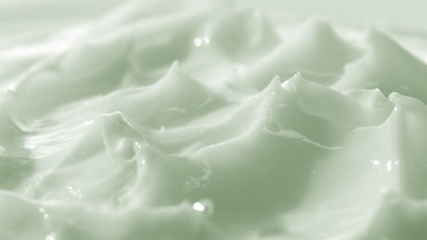 Macro crane turntable shot of green skin care cream surface